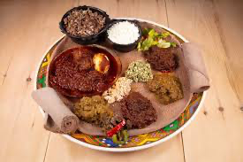 Habesha combination platter with meat stews, greens and injera